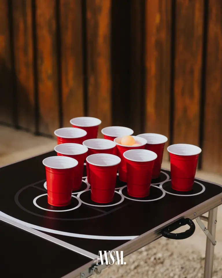 Beer-Pong-Tisch mit roten Bechern und Ball vor einer sonnenbeschienenen Holzwand am Buschenschank – Vineyard Edition, 24.05.2025