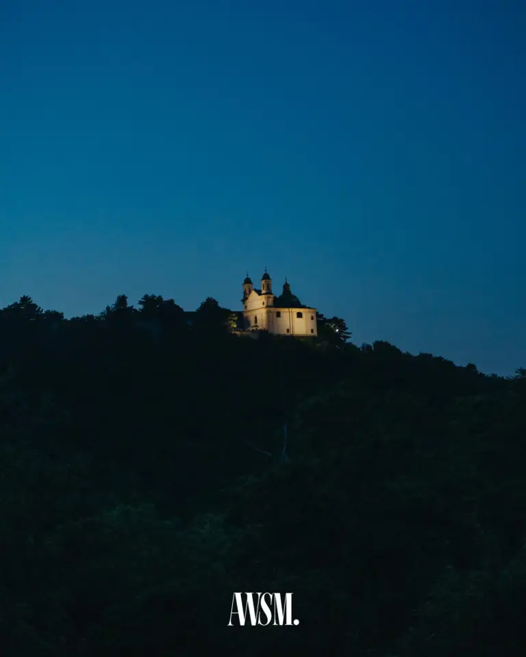 Beleuchtete Kirche auf dem bewaldeten Hügel zur blauen Stunde, vom Weinberg am Nussberg aus gesehen – Vineyard Edition, 24.05.2025