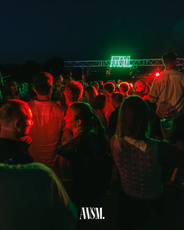 Feiernde Menge in rotem Scheinwerferlicht vor der Traverse mit grünem AWSM-Schriftzug bei Nacht – Vineyard Edition, 19.07.2025