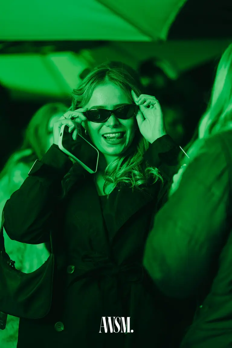Lachender Gast rückt die Sonnenbrille zurecht, Handy in der Hand, unter grün beleuchtetem Schirm – Vineyard Edition, 04.10.2025