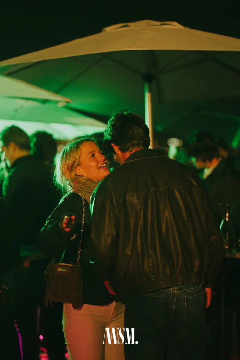 Lachender Gast im Gespräch mit einem Gast in Lederjacke unter den Schirmen am Nussberg – Vineyard Edition, 04.10.2025