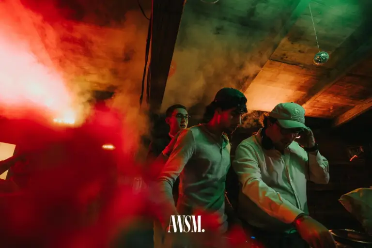 DJs am Pult im Nebel unter der Holzdecke mit Discokugel, rotes und grünes Licht – AWSM. GOES KAISER WIESN, 27.09.2026